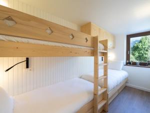 two bunk beds in a room with a window at Appartement familial rénové, au cœur de Courchevel Le Praz, proche des pistes et commodités - FR-1-568-30 in Courchevel
