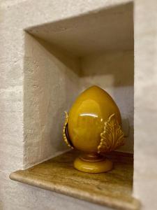 un uovo giallo seduto su uno scaffale in una scatola di Il Vicolo Grottaglie a Grottaglie