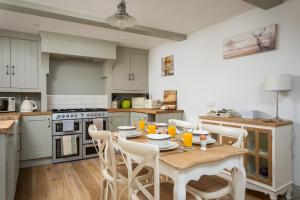 a kitchen with a table and chairs in a kitchen at The Bolt Hole, Winchcombe, Charming Dog-Friendly Cottage in Winchcombe