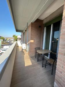 einen Balkon mit einem Tisch und Stühlen auf einem Gebäude in der Unterkunft Meridian A23 in Reggio nell'Emilia