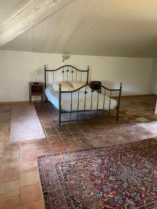 1 dormitorio con cama, mesa y alfombra en La Gandonne, en Caderousse