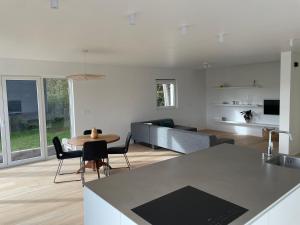 a kitchen and living room with a table and a couch at Nouvelle construction dans le village de Fays in Theux