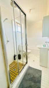 y baño con ducha de cristal y aseo. en Quiet family Townhouse in Wollongong CBD en Wollongong