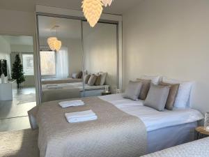 Un dormitorio con una cama grande y un espejo. en Arctic Luxury Apartment, en Rovaniemi