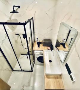 a white bathroom with a sink and a mirror at Green Side Studio in Michalovce