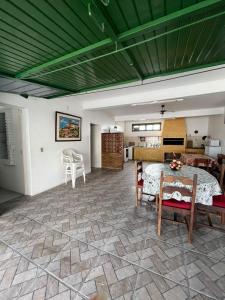 a large living room with a table and chairs at Linda casa para temporada em FRENTE A PRAIA em São Lourenço do Sul in São Lourenço do Sul