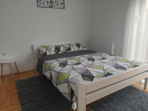 a bedroom with a bed with a colorful comforter at Nikola NS in Novi Sad