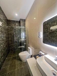 een badkamer met een toilet, een douche en een wastafel bij Villa Amory Mui Ne in Mũi Né