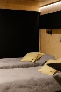 a bedroom with two beds and a black wall at Hotel OmaBox - Ylivieska - Oma huoneisto saunalla in Ylivieska