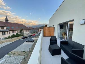 a balcony with chairs and a view of a street at Appartement au pied du Mont-Blanc 2! in Sallanches