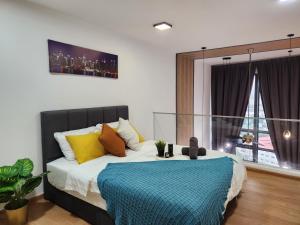 a bedroom with a bed with a blue blanket on it at EkoCheras Duplex Suite by Ohana Home in Kuala Lumpur