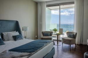a bedroom with a bed and a view of the ocean at Limassol Del Mar in Limassol