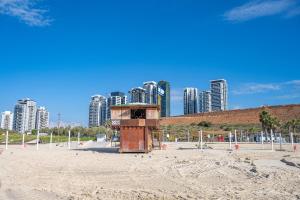 a lifeguard tower on a beach with tall buildings at Hi-Yam SeaView Apartments & Suites - יש ממ"ד in Bat Yam