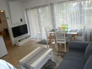 a living room with a couch and a table and a television at Tac Home 2-Zimmer Wohnung in Sindelfingen