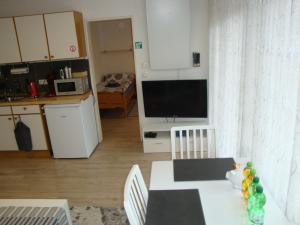a living room with a kitchen and a table with chairs at Tac Home 2-Zimmer Wohnung in Sindelfingen