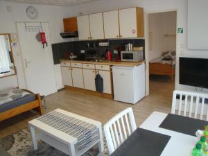 a living room with a kitchen and a table and chairs at Tac Home 2-Zimmer Wohnung in Sindelfingen
