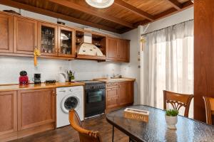 アテネにあるAngi&George houseのキッチン(木製キャビネット、テーブル、コンロ付)