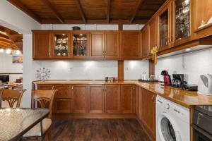 アテネにあるAngi&George houseのキッチン(木製キャビネット、食器洗い機付)