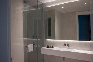a bathroom with a shower and a sink and a mirror at Limassol Del Mar in Limassol