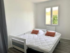 Una cama blanca en una habitación con ventana. en Villa Saint Mart, en Saint-Martin-de-Ré
