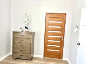 a room with a wooden door and a dresser at Healing in the City in Montego Bay