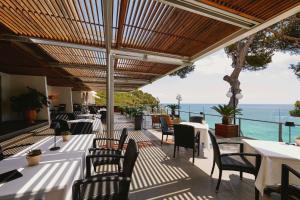 un ristorante con tavoli e sedie e vista sull'oceano di Hotel Santa Marta a Lloret de Mar