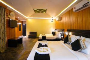 una camera d'albergo con due letti e una televisione di Havelock Island Beach Resort a Isola di Havelock