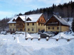 a house with cars parked in the snow at Chata Sudecka in Sienna