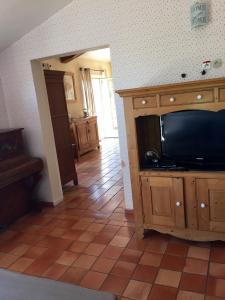 uma sala de estar com televisão e piso em azulejo em Mas Chamarel, la Provence entre vignes et oliviers proche de la mer em Sanary-sur-Mer