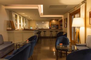 a living room with couches and tables and a bar at Hotel Santa Marta in Lloret de Mar