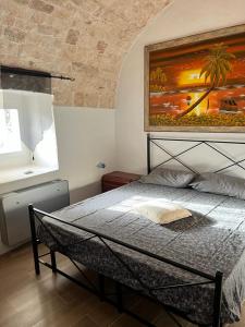 a bedroom with a bed with a painting on the wall at Trullo Sofia in Monopoli