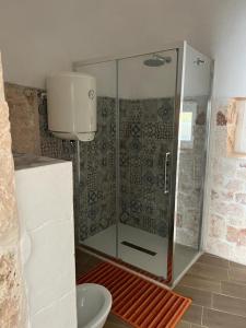 a shower with a glass door in a bathroom at Trullo Sofia in Monopoli