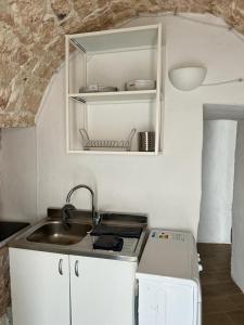 a small kitchen with a sink and a stove at Trullo Sofia in Monopoli