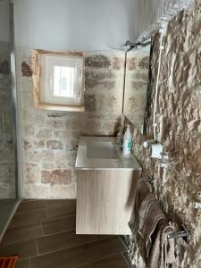 a bathroom with a sink and a brick wall at Trullo Sofia in Monopoli