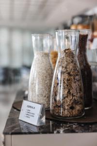 three glass vases filled with oats on a table at Limassol Del Mar in Limassol