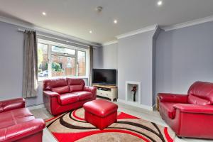 a living room with red furniture and a tv at Finest Retreats - Royal Nights Place in Rochester