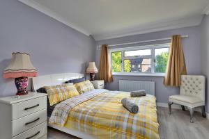 a bedroom with a bed and a chair and a window at Finest Retreats - Royal Nights Place in Rochester