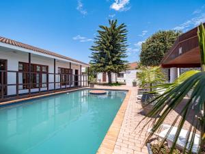 a swimming pool in front of a house at 5 Third Avenue Guesthouse in Port Elizabeth