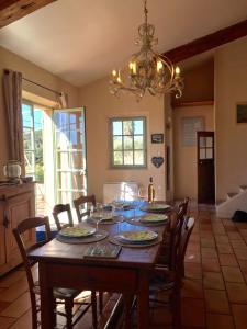 uma mesa de jantar com cadeiras e um lustre em Mas Chamarel, la Provence entre vignes et oliviers proche de la mer em Sanary-sur-Mer