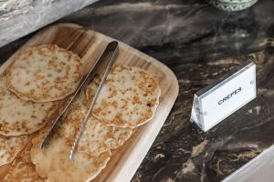 a table with a plate of pancakes and a knife at Limassol Del Mar in Limassol