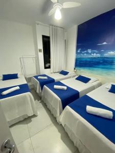 vier bedden in een kamer met uitzicht op de oceaan bij Apartamento vista mar Atalaia todos quartos climatizados in Aracaju