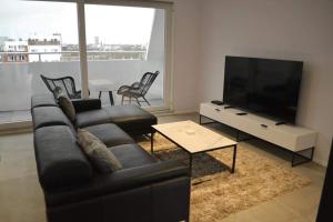 a living room with a couch and a flat screen tv at Hotel Ter Streep in Ostend