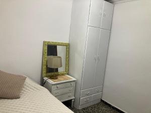 薩拉戈薩的住宿－Disfruta tu estancia en Zaragoza!，一间卧室配有一张带镜子和梳妆台的床