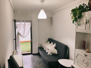 uma sala de estar com um sofá com almofadas em Disfruta tu estancia en Zaragoza! em Saragoça