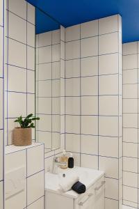 La salle de bains est pourvue d'un lavabo et d'un miroir. dans l'établissement CHAMBRE ARTY CHEZ MINUIT DEUX, à Mâcon