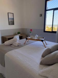 una habitación con 2 camas y una mesa con flores. en Apartamento vista mar Atalaia todos quartos climatizados, en Aracaju