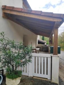 a patio with awning over a white fence at Maison 4 personnes in Caillac