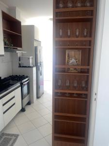 a kitchen with a wooden wall with wine glasses at Apartamento vista mar Atalaia todos quartos climatizados in Aracaju
