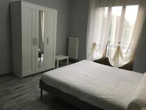 a bedroom with a white bed and a window at Il Borgo Antico: Vista su Reggia di Venaria Reale in Venaria Reale