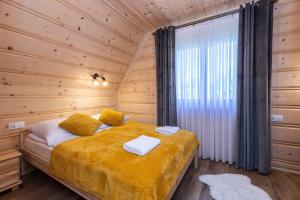 a bedroom with a bed in a wooden cabin at TatryTop Domek Białka in Białka Tatrzańska